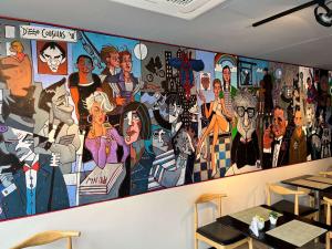 a wall mural in a restaurant with a group of people at ibis Styles Montevideo Biarritz in Montevideo
