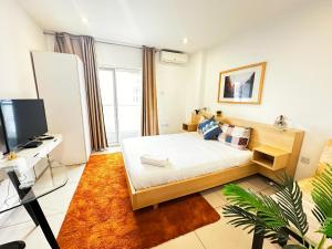 a small bedroom with a bed and a tv at Gallery Apartments by BestWest Hospitality in Accra
