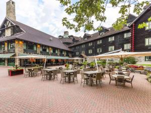 a courtyard with tables and chairs in front of a building at Fairmont Le Chateau Montebello in Montebello