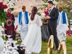 a bride and groom walking down the aisle at their wedding at Mövenpick Resort Aswan in Aswan
