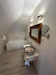 een badkamer met een wastafel, een spiegel en een bad bij Karczma Rzym Bydgoszcz S5 in Bydgoszcz