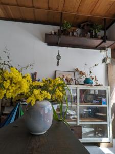 um vaso cheio de flores amarelas sentado numa mesa em iro em Sado