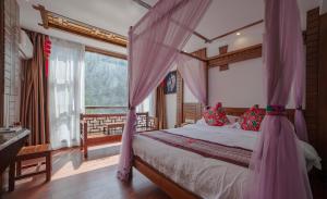 um quarto com uma cama com uma rede mosquiteira cor-de-rosa em Zhangjiajie Memory Inn em Zhangjiajie