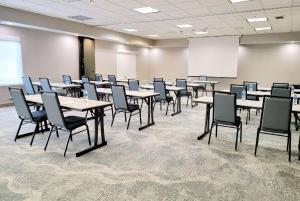 una sala de conferencias con mesas, sillas y una pizarra en Wyndham Garden Otsego-Minneapolis en Otsego