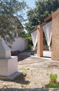 eine Terrasse mit weißen Vorhängen im Hof in der Unterkunft Casal Baratz in Santa Maria la Palma