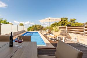 a patio with a table and a swimming pool at Villa Lantana ZadarVillas in Petrcane +38 photos