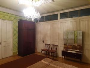 une chambre avec une table, deux chaises et un lustre dans l'établissement Tkhibuli geust house, à Tqibuli