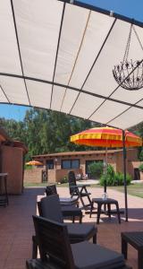 a patio with tables and chairs and an umbrella at Casal Baratz in Santa Maria la Palma