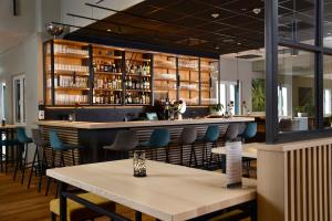 a bar in a restaurant with blue chairs and tables at Sure Hotel by Best Western Hilden-Düsseldorf in Hilden