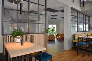 a restaurant with a table and chairs and windows at Sure Hotel by Best Western Hilden-Düsseldorf in Hilden