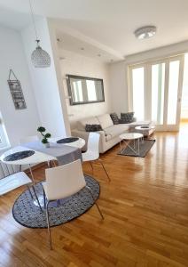 Belville City apartment في بلغراد: غرفة معيشة مع أريكة وطاولة وكراسي