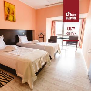 Habitación de hotel con 2 camas y escritorio en Hotel Delpack, en Timisoara
