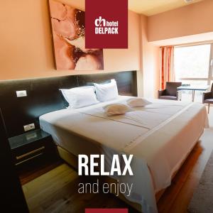 a bed in a hotel room with the words relax and enjoy at Hotel Delpack in Timişoara