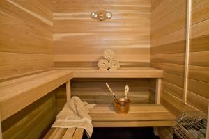 a wooden sauna with a wooden bench and a bucket at Aparte Lux in Jūrmala