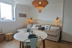 ein Wohnzimmer mit einem Tisch und einem Sofa in der Unterkunft BERCK Beach Attitude 160 QUEEN SIZE très confort - 3min de la plage in Berck-sur-Mer