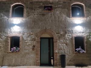 a stone building with a door and windows and flowers at Fuori Borgo in Campobasso