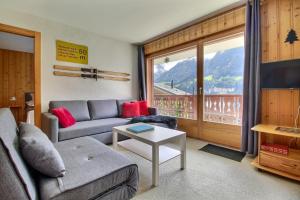 a living room with a couch and a table at Cretes 14 And Its Vaste Terrasse in Champéry +5 photos
