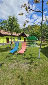 zwei Stühle im Gras in einem Park in der Unterkunft Vila Drumetului in Comarnic
