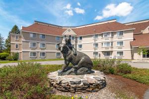 a statue of a bear in front of a building at Black Bear Inn, Ascend Hotel Collection in Orono