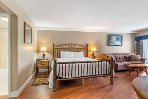 a bedroom with a bed and a living room at Black Bear Inn, Ascend Hotel Collection in Orono