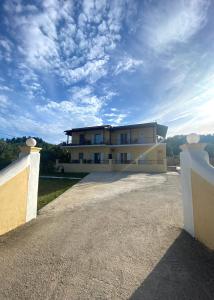a large white house with a cloudy sky at La vita e Bella Apartments by Corfuescapes in Kontokali