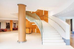 a staircase with glass railings in a building at London Twickenham Stadium Hotel, a member of Radisson Individuals in Twickenham
