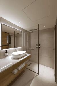 a bathroom with a sink and a glass shower at Radisson Hotel Graz in Graz