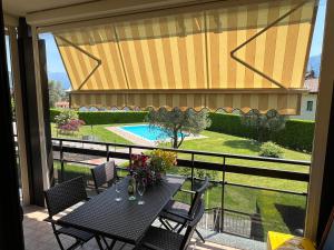 a balcony with a table and chairs and a view of a pool at Alba sul Lago in Lenno