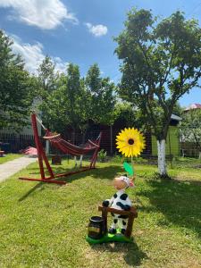 a toy cow sitting on a bench in the grass at Vila Drumetului in Comarnic