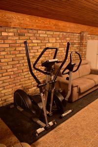 a bike parked next to a brick wall with a couch at Gyömbér Tanya in Ásotthalom