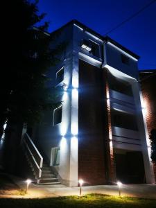 a building with lights on the side of it at night at Vila Breza in Soko Banja
