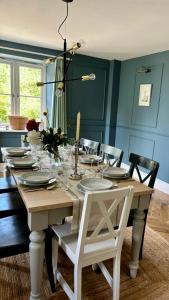 einen Esstisch mit Tellern und Gläsern darauf in der Unterkunft Luxury farmhouse in secluded Cotswold valley in Uley