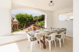 a white dining room with a table and chairs at Villa Bouganvilla in Tossa de Mar