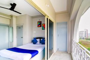 a bedroom with a balcony with a bed and a window at Hotel JMT Inn in kolkata +4 photos