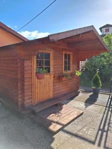 a wooden shed with two potted plants on it at ODRANSKA KLET D.O.O. in Sisak