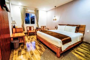 a bedroom with a large bed and a desk and chair at BB Hotel&Resort in Phú Quốc