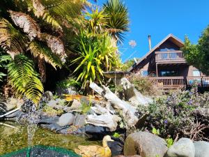 a garden with a pond in front of a house at Dakune Chill - The Lodge in Ohakune