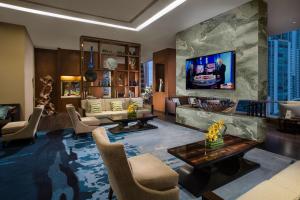 a living room with a tv on a wall at Ascott Kuningan Jakarta in Jakarta