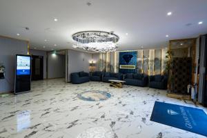 una hall con pavimento in marmo e lampadario pendente. di Grand Sapphire Hotel & Banqueting a Croydon