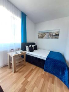 um pequeno quarto com uma cama e uma mesa em Willa Szafir z WIDOKIEM NA ZALEW em Krynica Morska