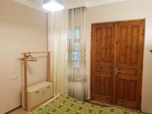 a bedroom with a bed and a wooden door at Tkhibuli guest house in Tqibuli
