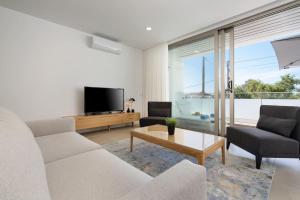 a living room with a couch and a tv at Dália modern apartment Five minutes to beach in Luz