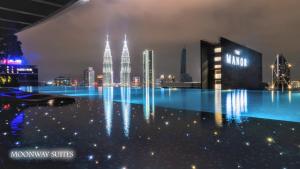 a pool with a view of a city at night at MOONWAY SUITES At EATON KLCC in Kuala Lumpur