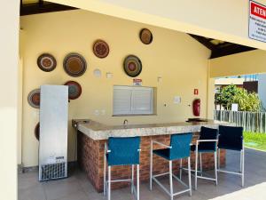 a kitchen with a bar with blue bar stools at Village Baixio in Baixio