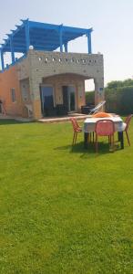 a table and chairs in a yard with a house at first row villa in Marsa Matruh