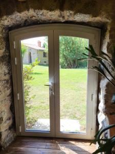 an open door with a view of a yard at chambre ciel et terre et chambre terrasse in Saint-Laurent-de-Cerdans +2 photos