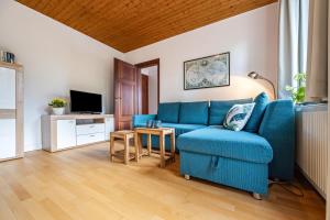 BendestorfにあるFerienwohnung Abendsonneの青いソファとテレビのあるリビングルーム