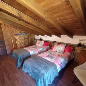 2 camas en una habitación con techos de madera en Cabaña Jerreru (vivienda vacacional), 