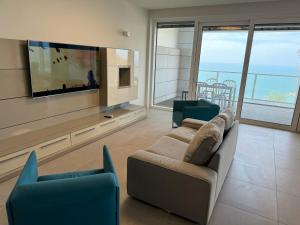 a living room with a couch and a flat screen tv at Prince Palace Netanya Central Beach in Netanya