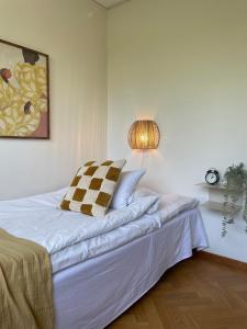 ein Schlafzimmer mit einem weißen Bett mit einer Lampe in der Unterkunft Ewa & Maude Hotel Aston Villa in Göteborg